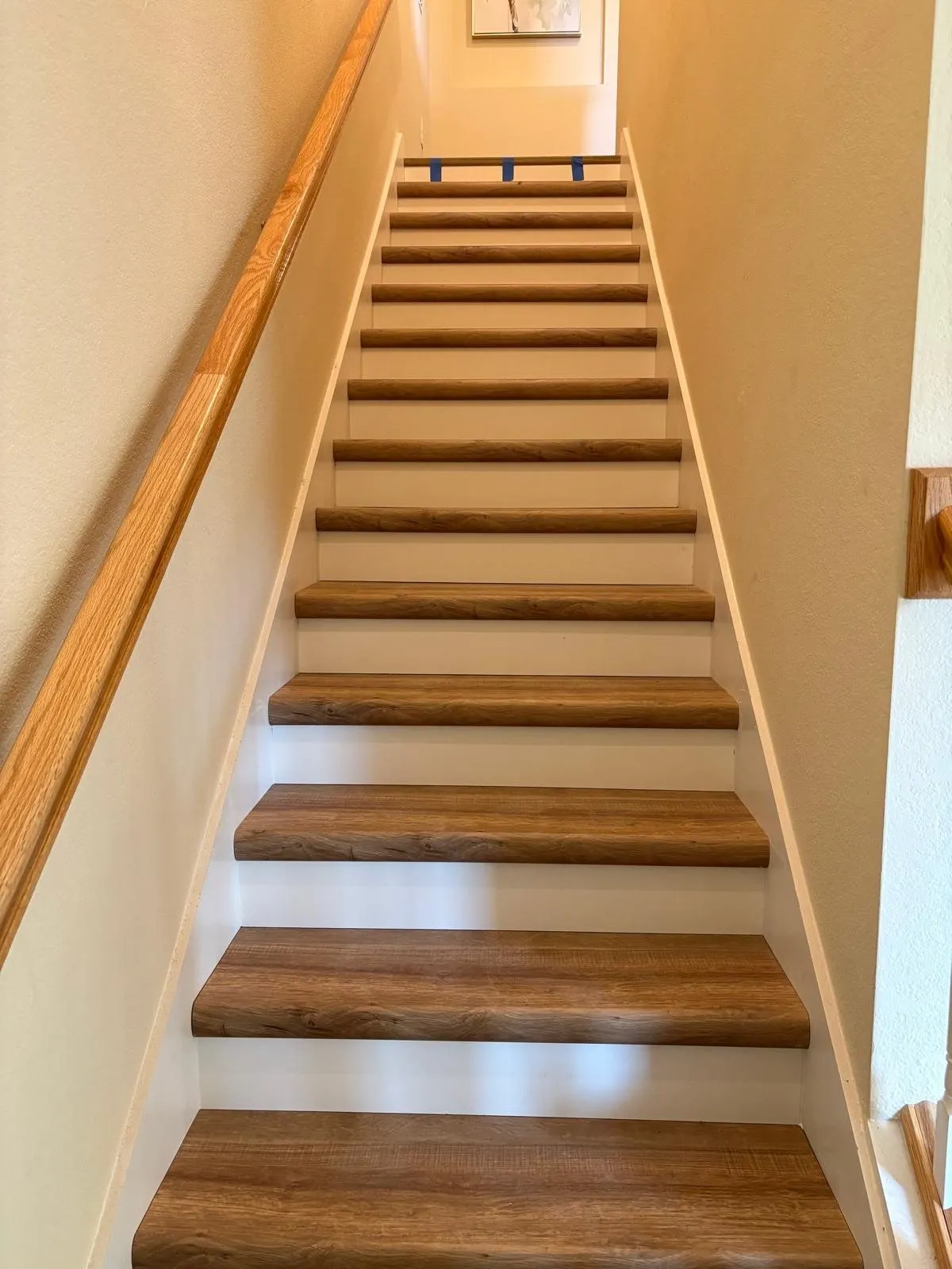 Long staircase with warm oak vinyl treads and white risers